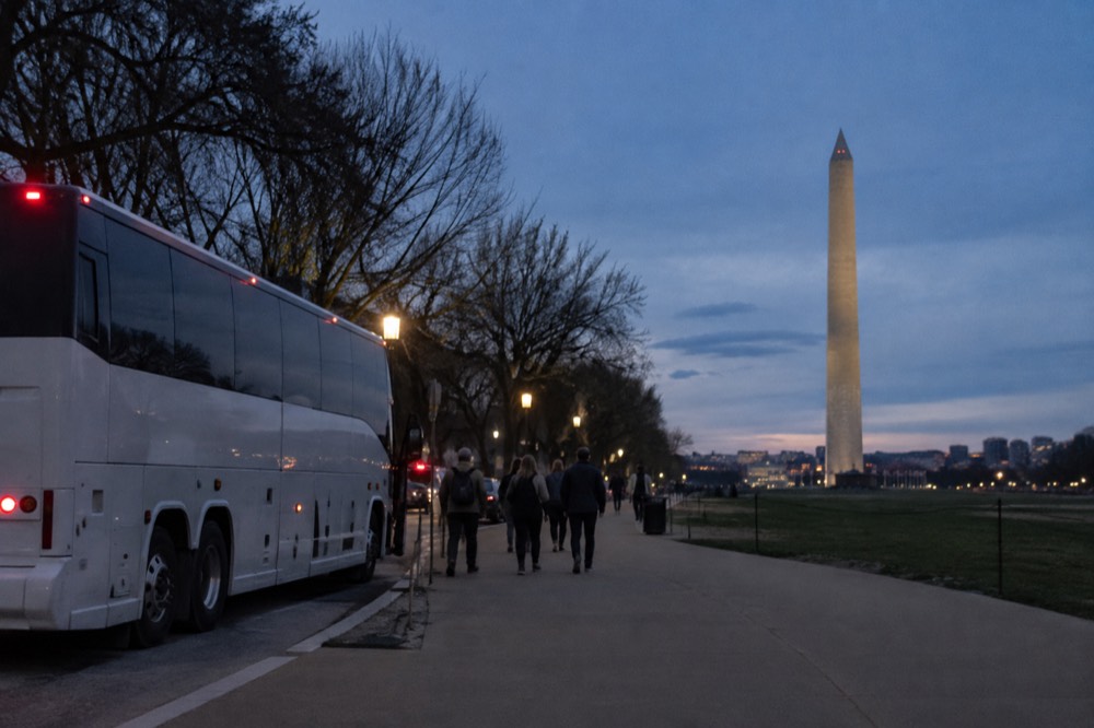 A tour coach parked near the National Mall with the Washington Monument in the background