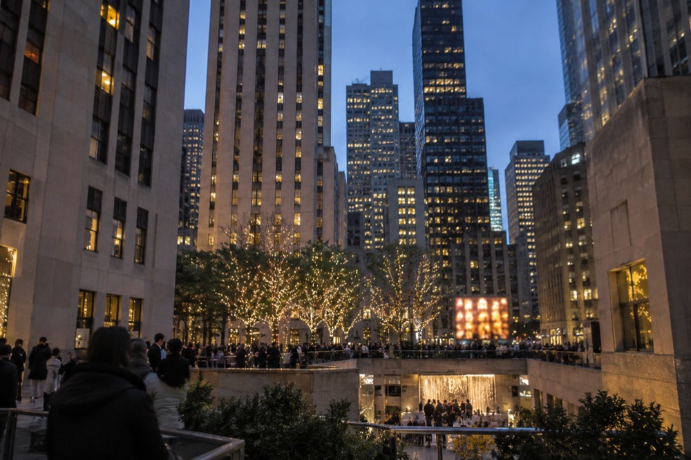The Rockefeller Center plaza at dusk with the surrounding Midtown towers lit up