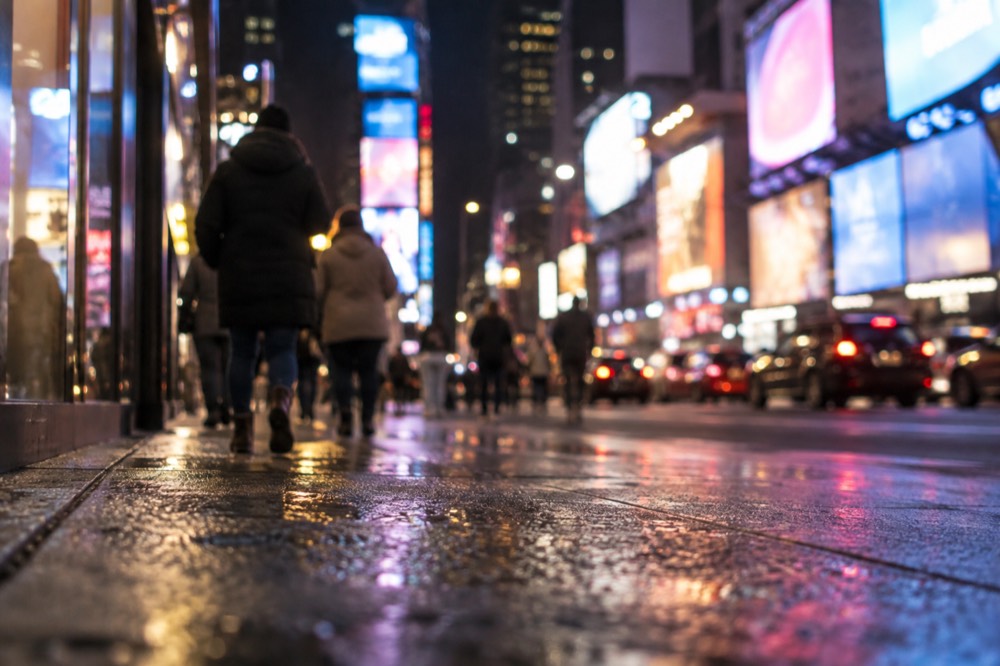 Times Square at night with illuminated billboards and dense pedestrian crowds