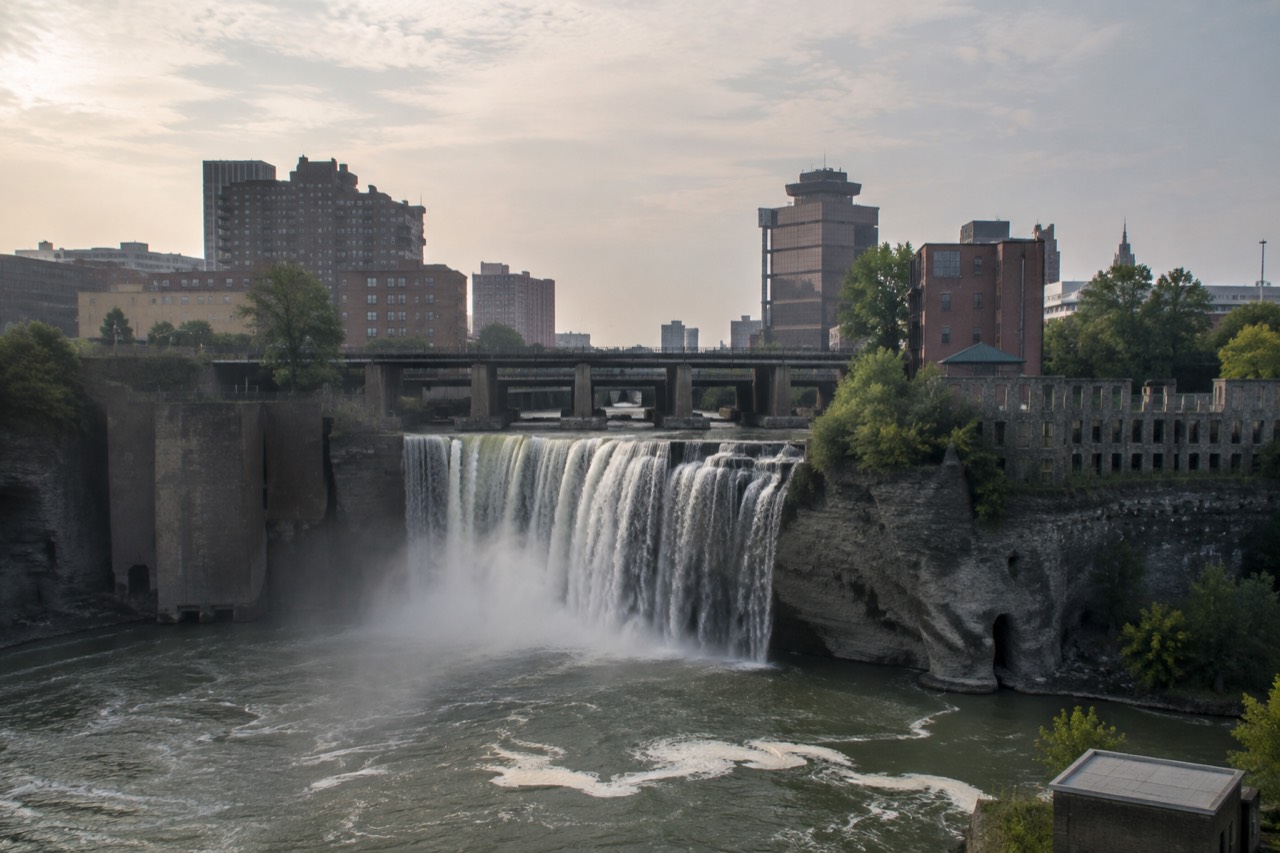 The High Falls waterfall in downtown Rochester with old industrial brick buildings along the gorge