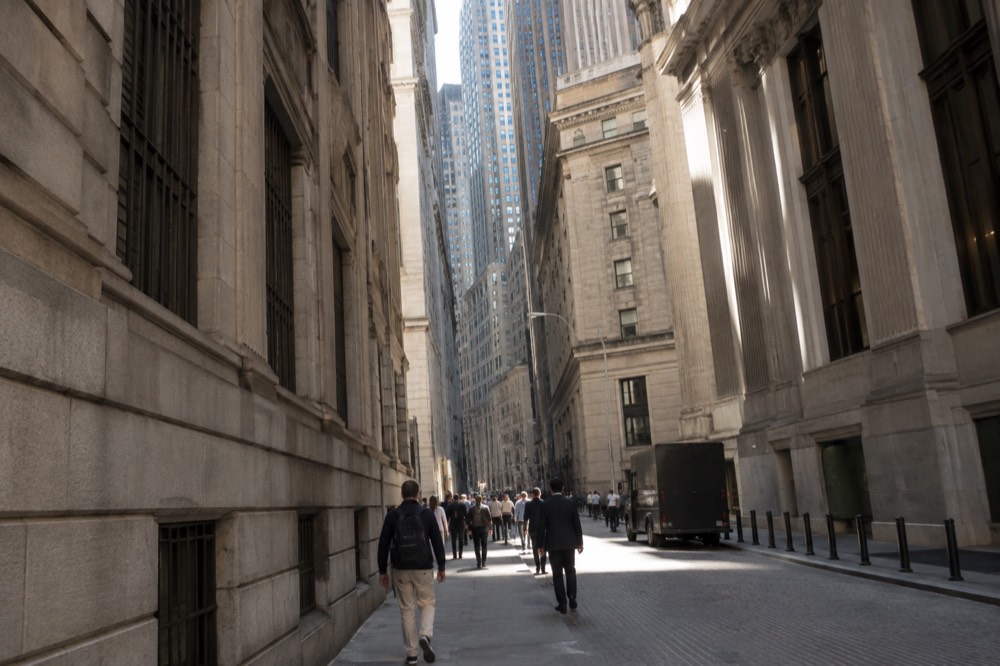 The narrow canyon of Wall Street in Lower Manhattan with tall office towers rising on both sides