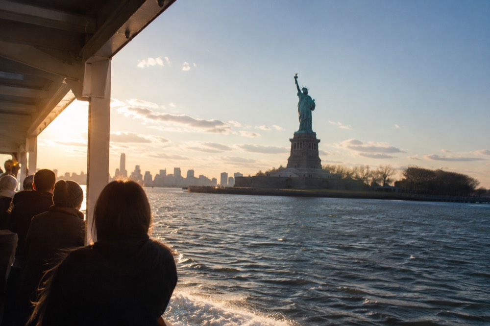 A sightseeing boat passing the Statue of Liberty in New York Harbor