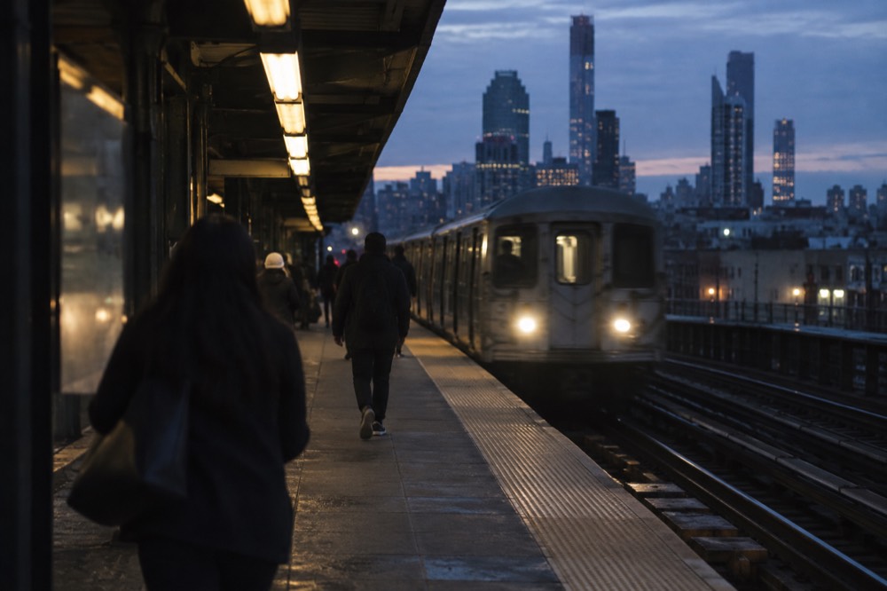 A subway platform in Manhattan with a Jamaica-bound train arriving