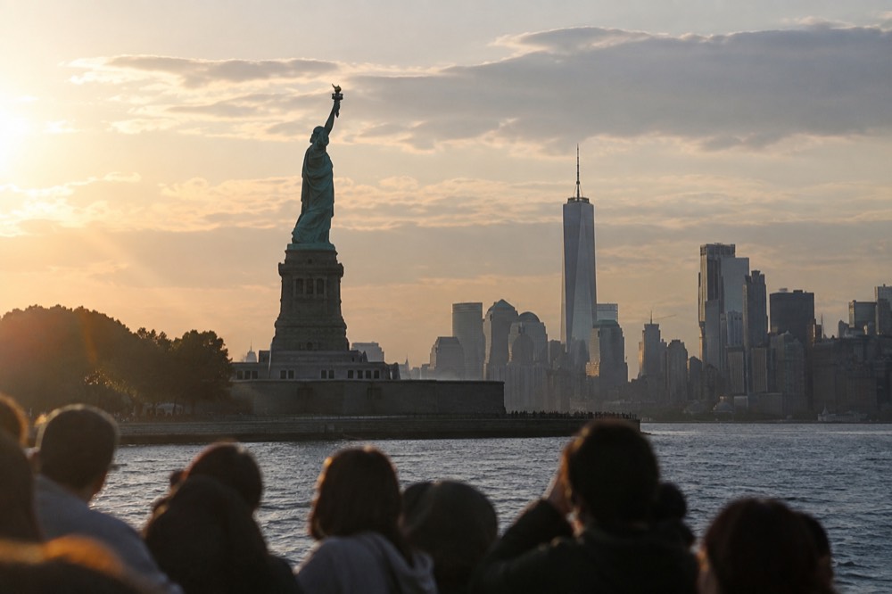 The Statue of Liberty seen from a boat on New York Harbor, with Lower Manhattan behind it