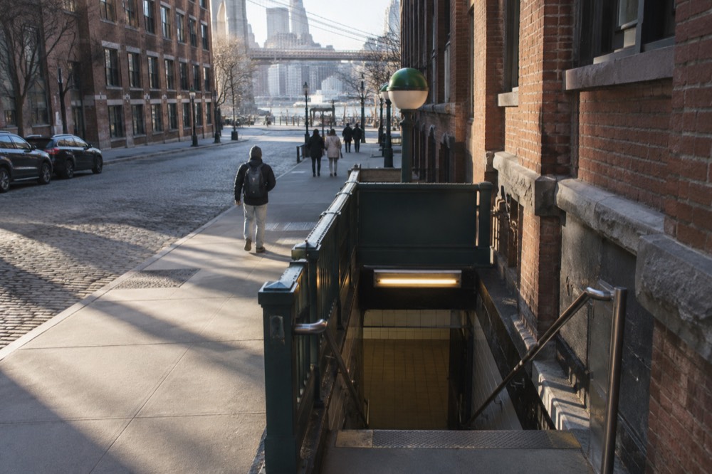 York Street subway station entrance on a quiet Dumbo street with brick walls