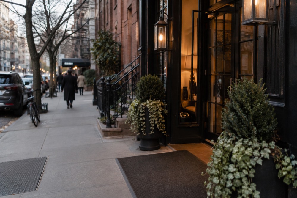 A small boutique hotel entrance on an East Village side street with a lit doorway
