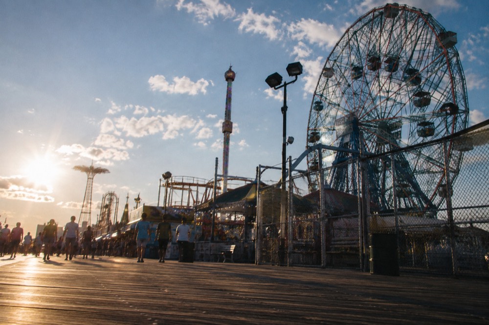 The Coney Island boardwalk and amusement park rides against a summer sky