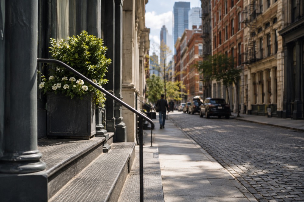 A quiet Tribeca street with converted brick and cast-iron loft buildings under a bright sky