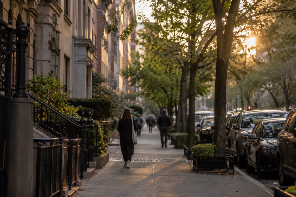 Wide residential avenue on the Upper West Side with rows of apartment buildings and green trees