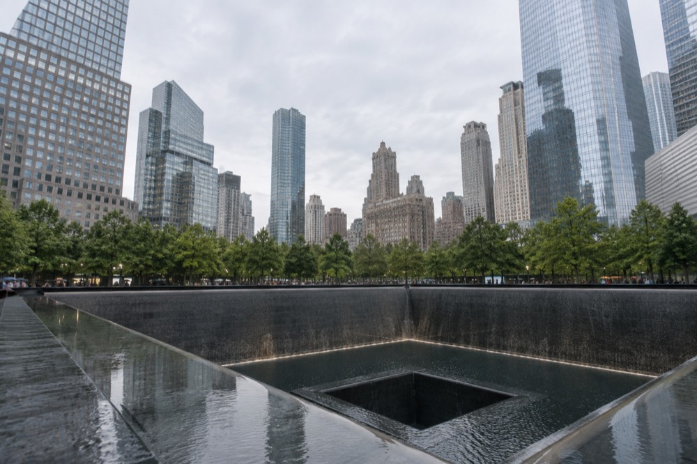 The two reflecting pools of the 9/11 Memorial set into the stone plaza of the World Trade Center site