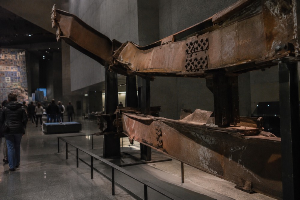 A massive bent steel column from the World Trade Center displayed inside the dimly lit museum hall