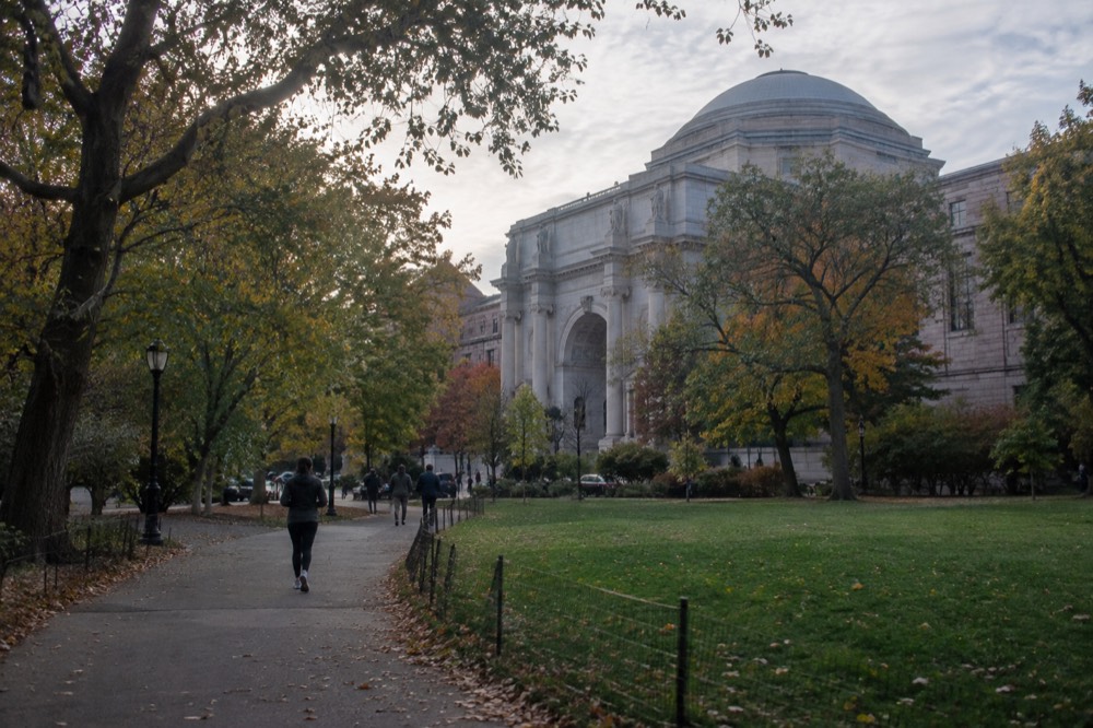 The museum building seen from across a green park with trees and a pathway in the foreground
