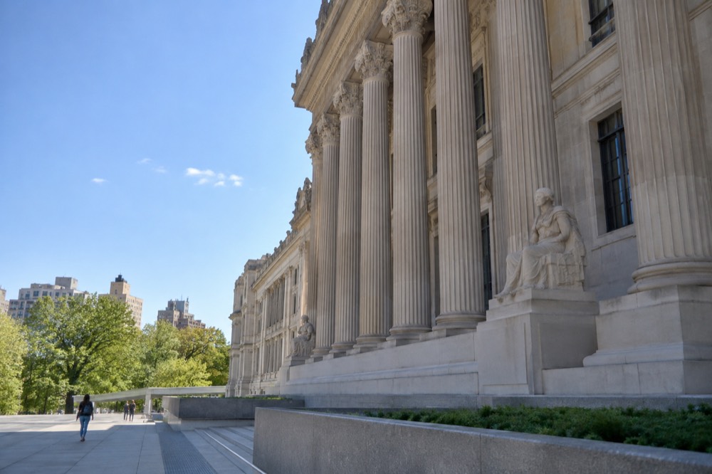Sunlight falling on stone architectural details along the Brooklyn Museum's exterior columns