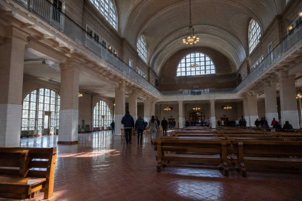 The Great Hall of the Ellis Island National Museum of Immigration with its arched windows and restored wooden benches