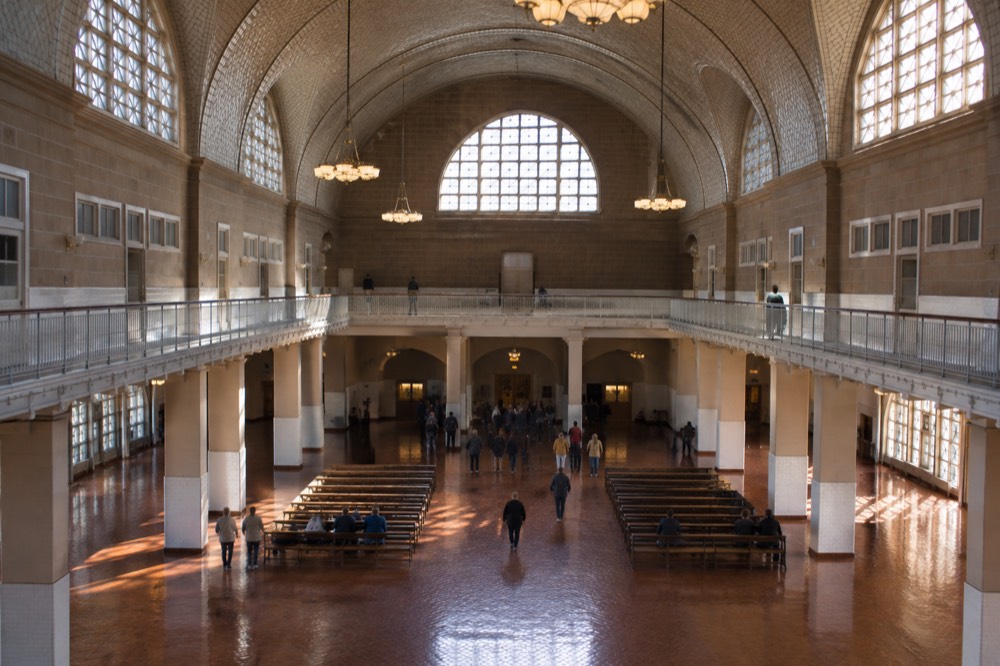 The Great Hall registry room at Ellis Island with its vaulted ceiling, tiled walls and rows of benches