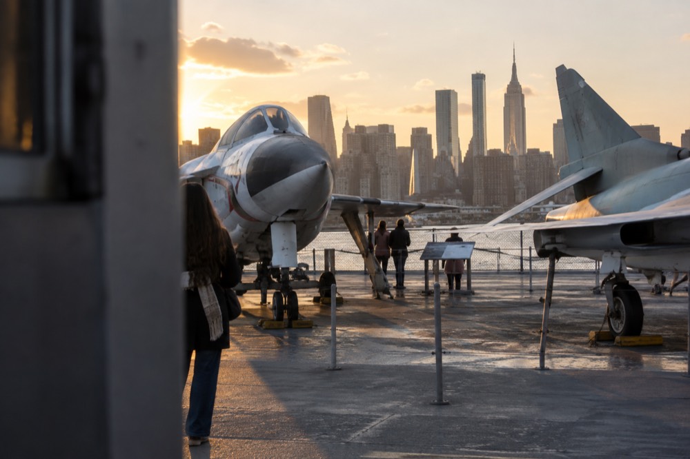 The flight deck of the aircraft carrier Intrepid on the Hudson River, with jets and the Manhattan skyline behind them