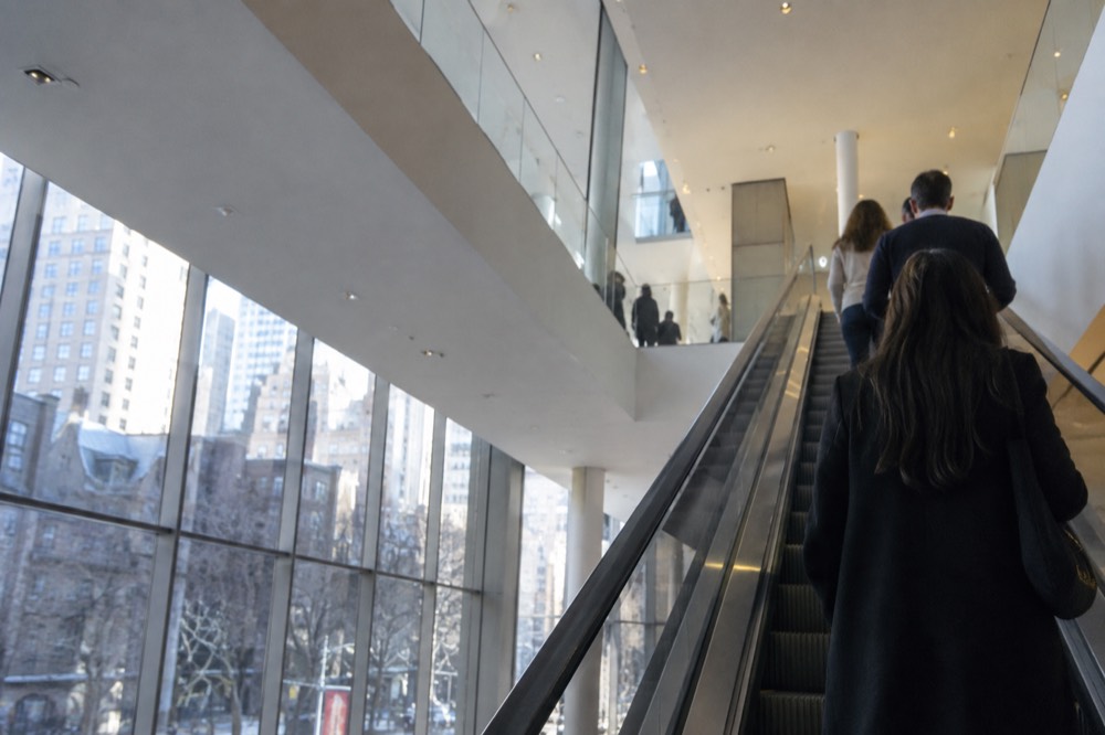 An escalator inside a modern museum carrying visitors up toward gallery floors