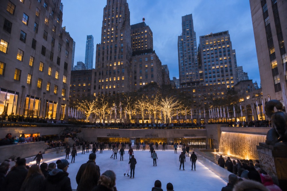 The seasonal ice rink in the Lower Plaza surrounded by flags and winter crowds