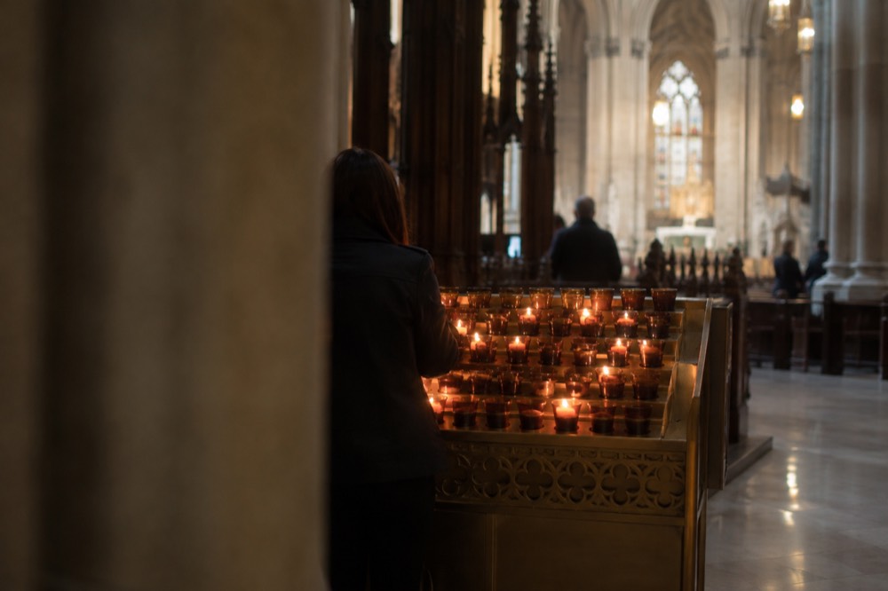 Candles glowing in a rack of votive holders inside St Patrick's Cathedral