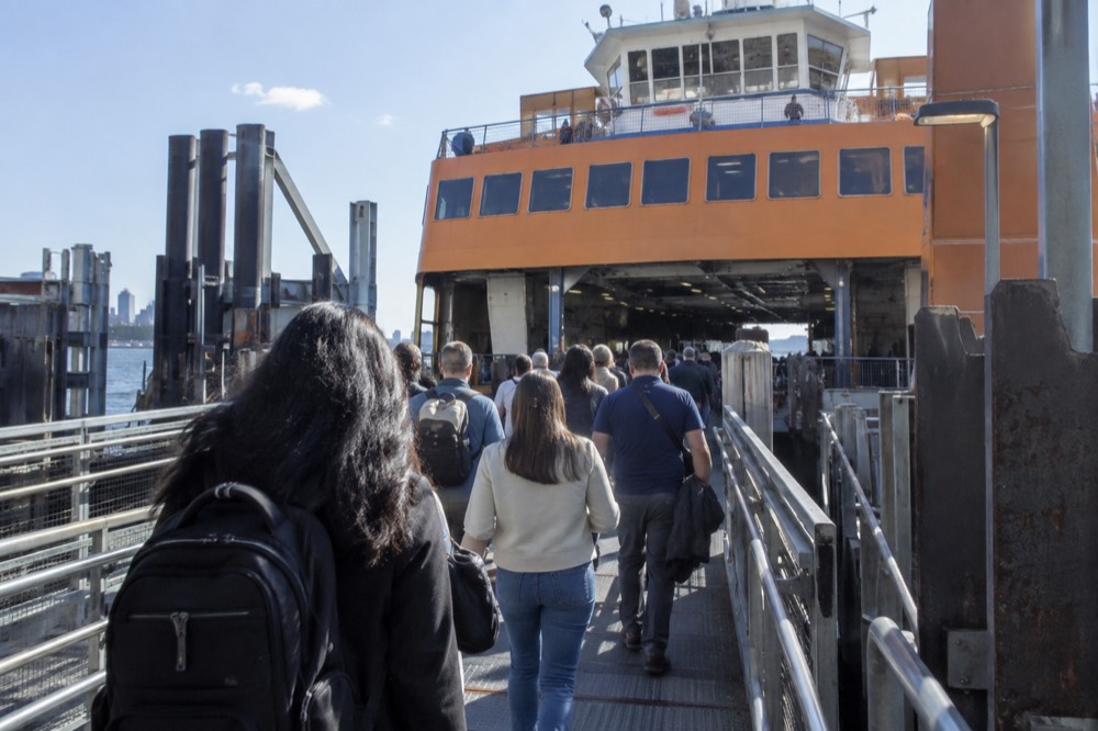 Passengers walking up the gangway to a Staten Island Ferry boat at a Manhattan terminal