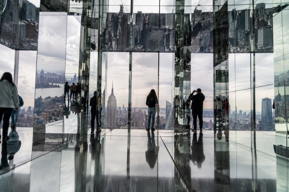 A mirrored room high above Manhattan reflecting the skyline and visitors infinitely in all directions