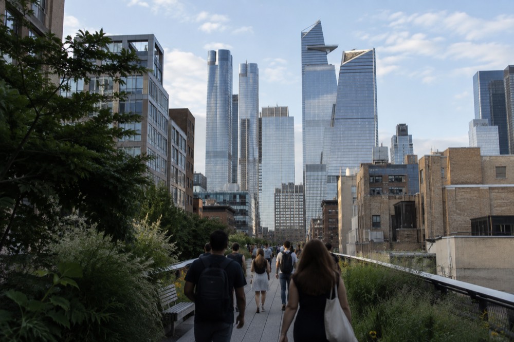 People walking the High Line toward Hudson Yards towers in the distance on a clear day