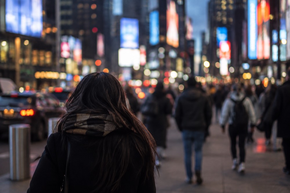 Times Square billboards glowing over a thin early morning crowd