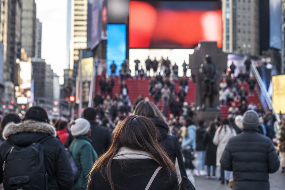The red steps of the TKTS booth rising above the Times Square crowd