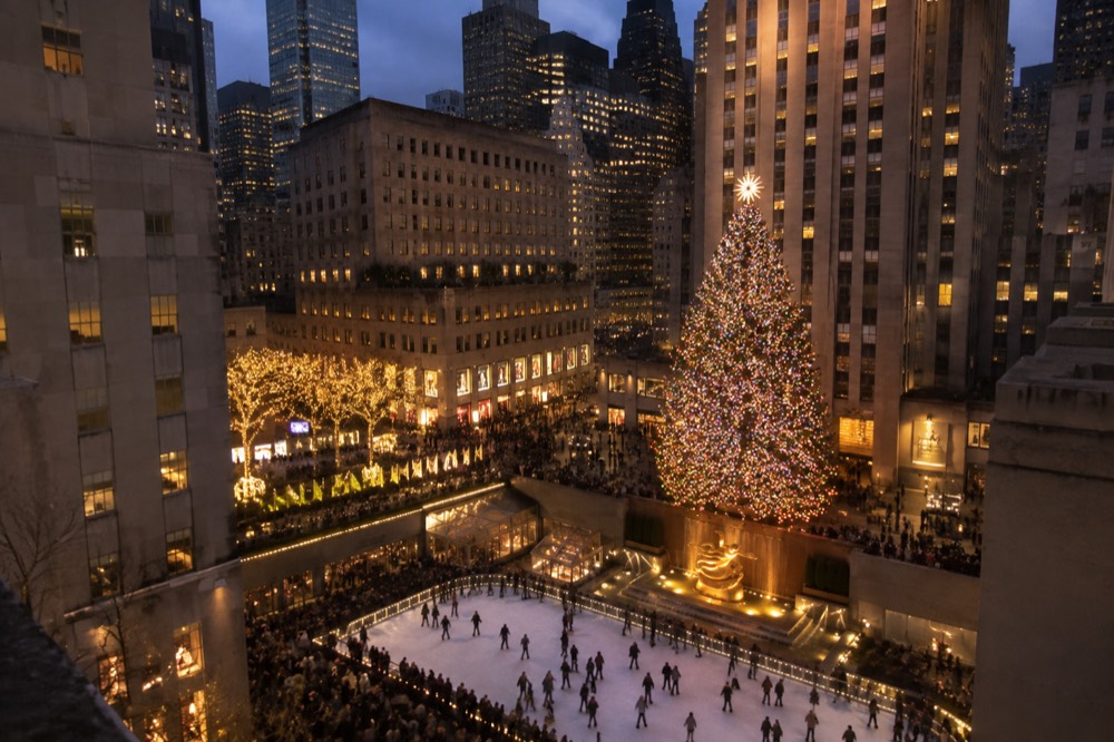 The Rockefeller Center Christmas tree seen from above at night with the skating rink below