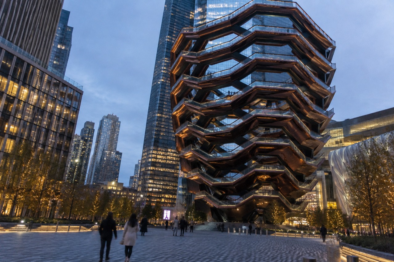 The copper-colored honeycomb staircase structure Vessel rising from the Hudson Yards plaza with surrounding glass towers