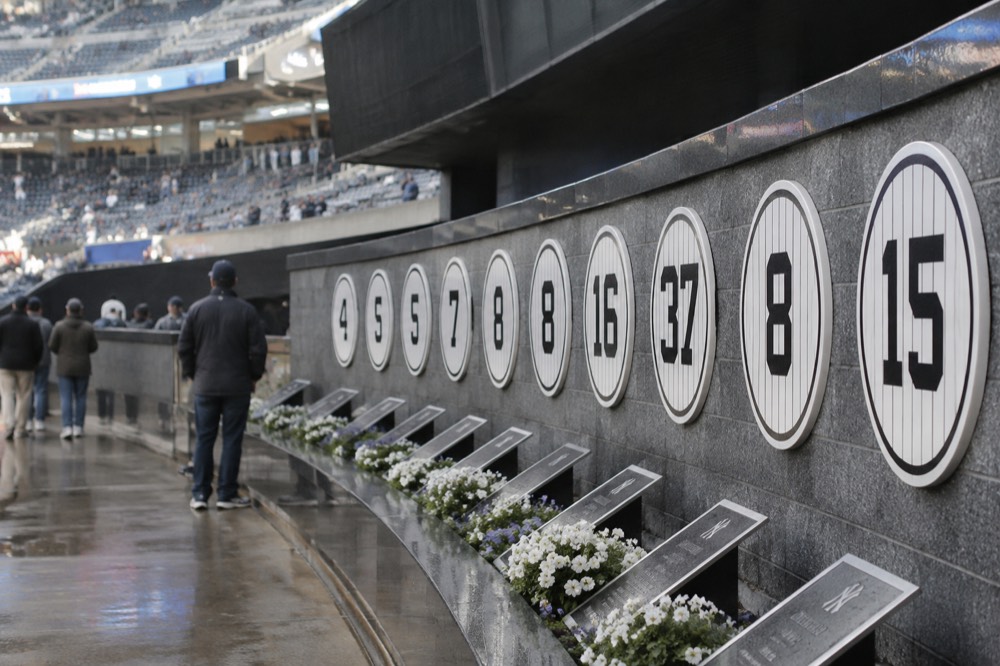 Retired numbers and monuments displayed along the wall at Monument Park inside Yankee Stadium