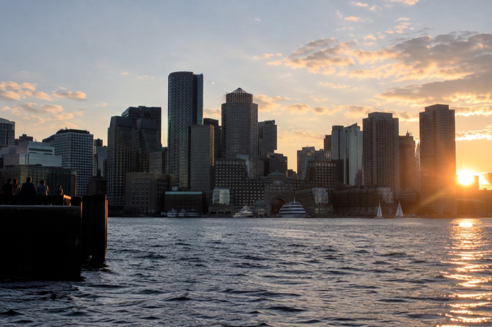 Boston skyline across the water at golden hour seen from the harbor