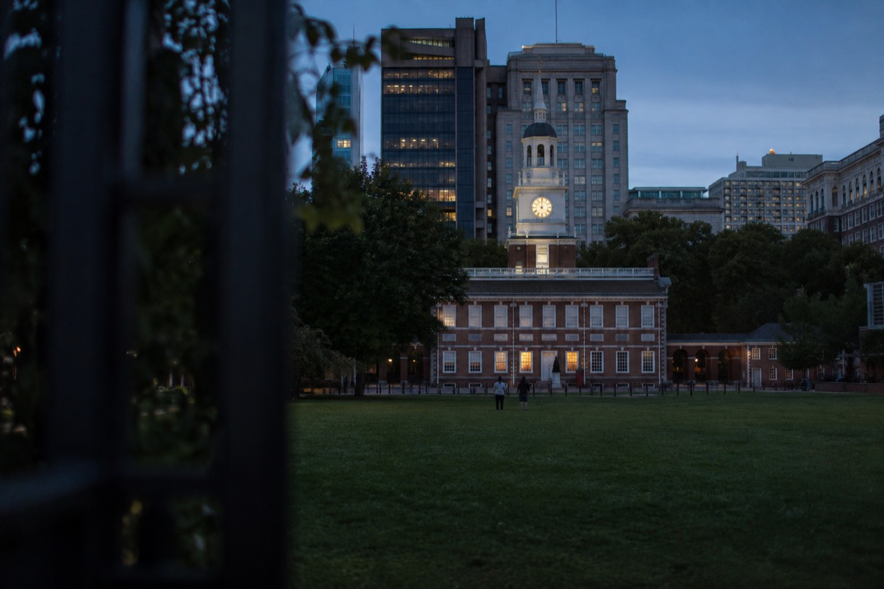 Independence Hall in Philadelphia seen from across a green lawn on a clear day