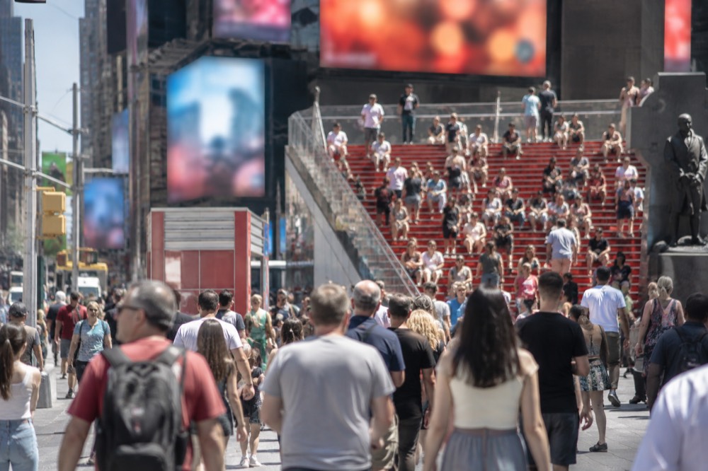 The red glass steps of the TKTS booth in Times Square with the discount board listing current Broadway shows