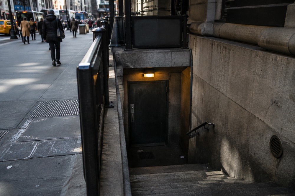 A hidden entrance door at the bottom of a dark staircase