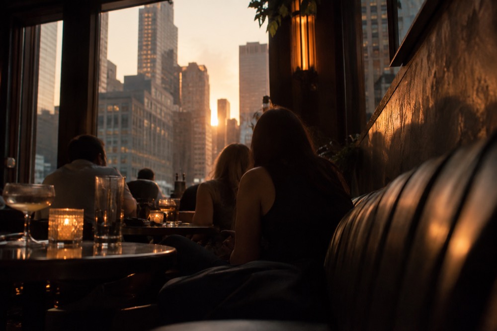 Guests seated at a candlelit banquette in a small hidden bar