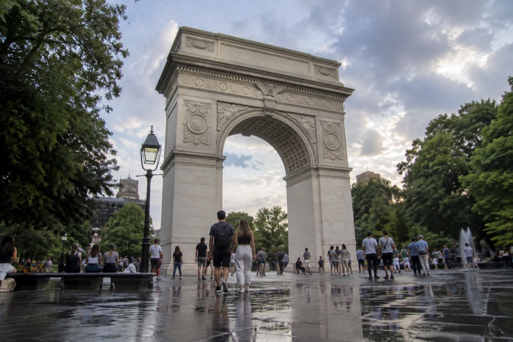 Washington Square Park arch with people gathered on a summer evening