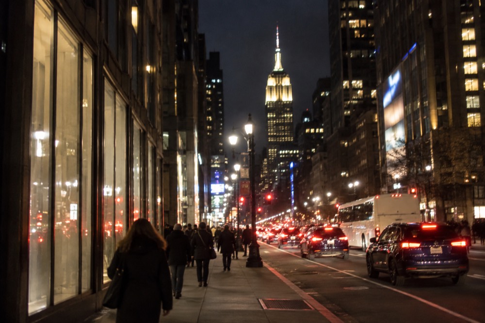 Fifth Avenue at night with the Empire State Building lit in the distance
