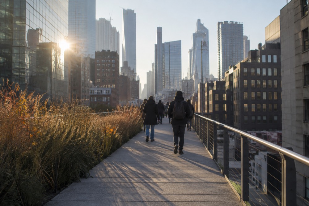 Visitors on an elevated park walkway with city towers behind them