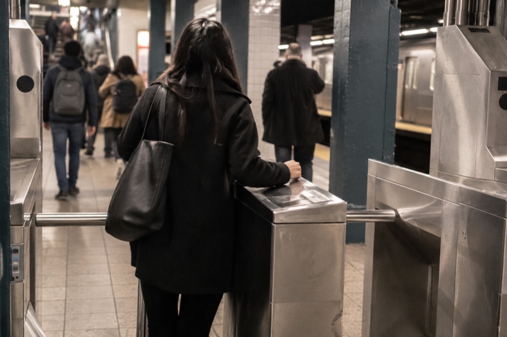 A subway turnstile in a tiled New York station