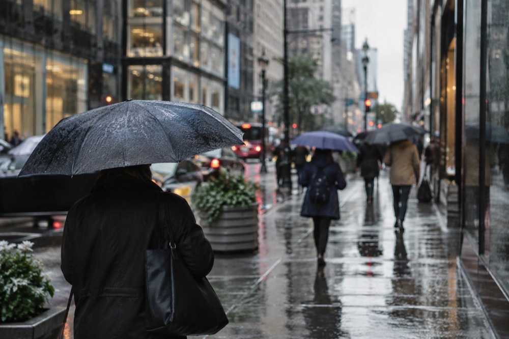 Umbrellas on a rainy New York street with reflections on the wet pavement
