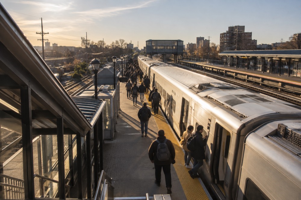 A Long Island Rail Road train at a Queens platform with passengers boarding