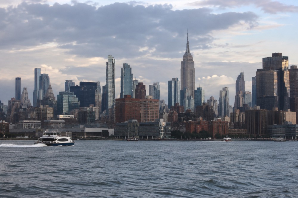 The Manhattan skyline seen from the water, with the Empire State Building rising above Midtown towers