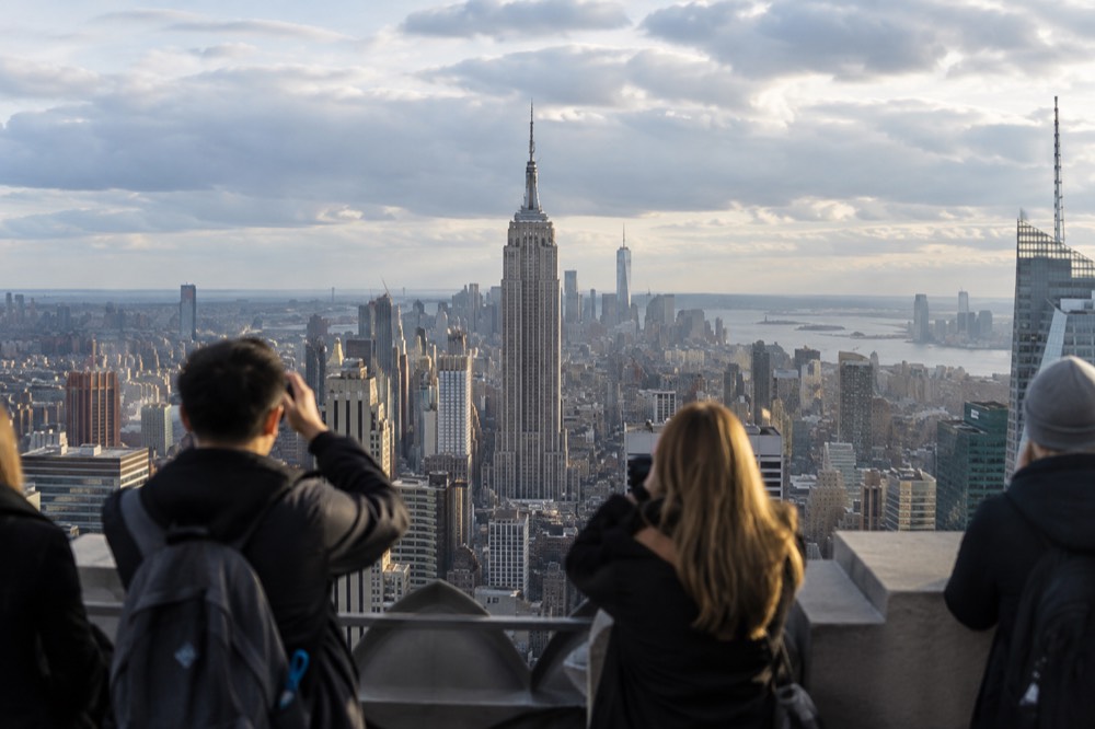 Observation deck visitors photographing the Empire State Building from across the skyline