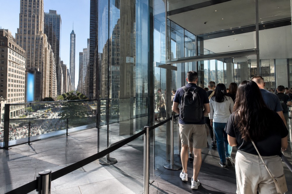 Pass holders walking up to an observation deck entrance in a glass lobby