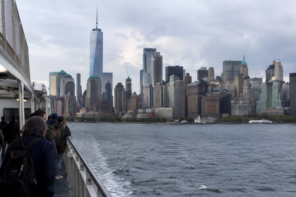 A ferry boat crossing New York Harbor with the Lower Manhattan skyline behind it