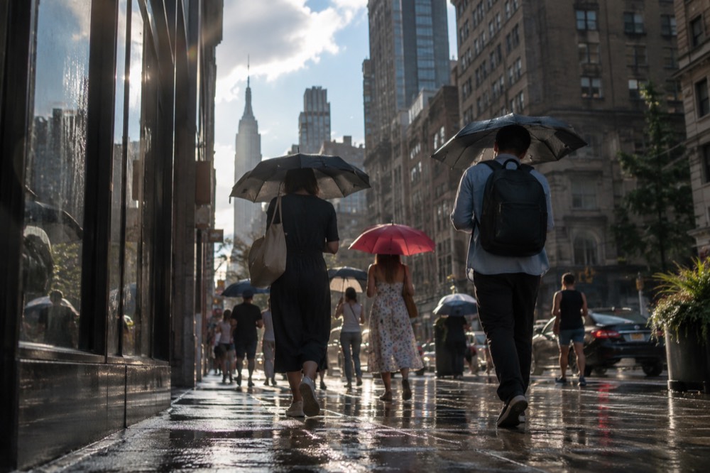 Umbrellas and summer crowds on a Manhattan street after a passing shower