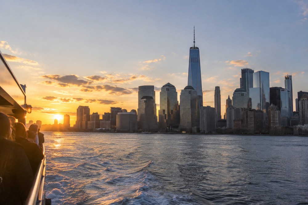 Sunset light over the Lower Manhattan skyline seen from the harbor water