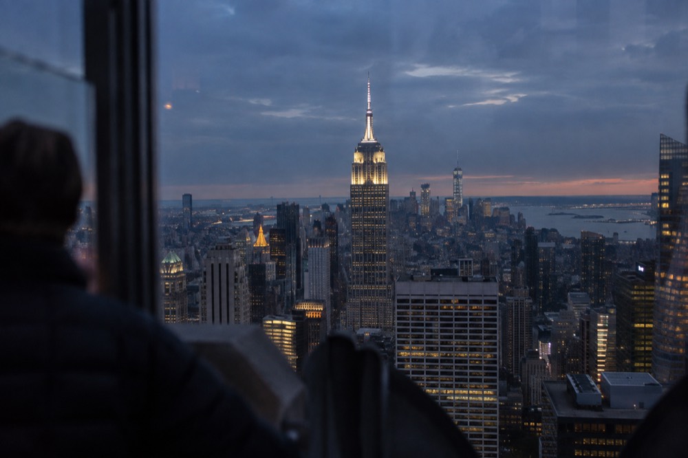 The Empire State Building seen at night from an observation deck across Midtown Manhattan