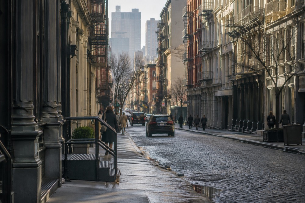 Cobblestone cast-iron street in SoHo with fire escapes and morning light